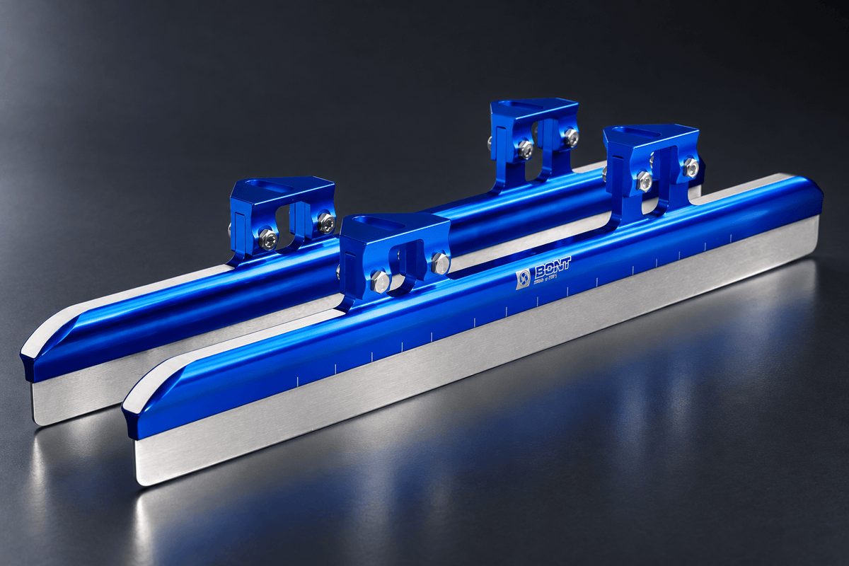 Pair of blue Bont GT3 short track blades with silver steel runners in a dark studio setting.
